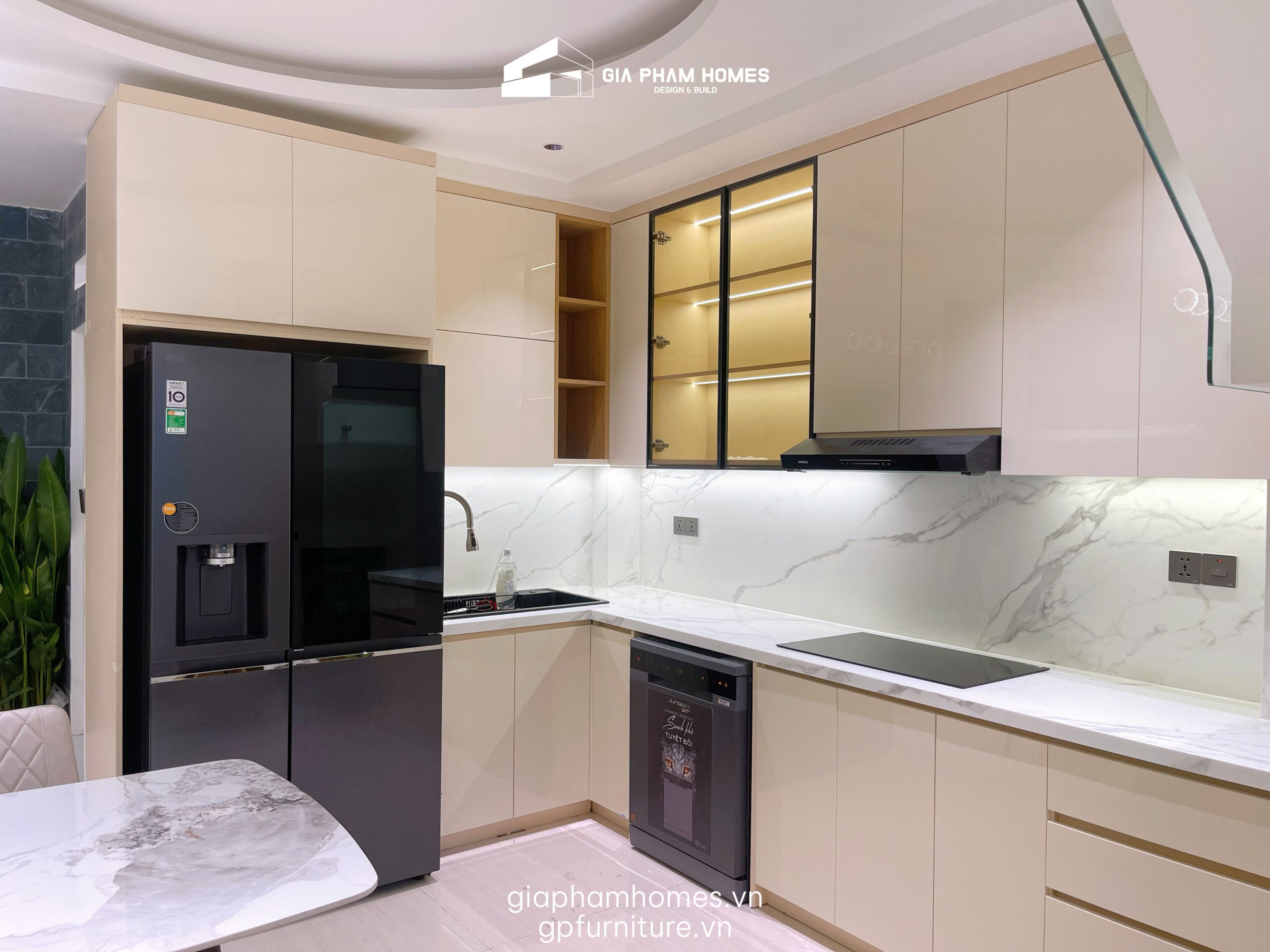 2. Phòng Bếp: Tiện Nghi Từng Centimet
Khu vực bếp nấu được thiết kế theo tiêu chí: Sạch sẽ - Gọn gàng - Sang trọng.
Tủ bếp Acrylic bóng gương: Sử dụng cốt gỗ MDF chống ẩm phủ Acrylic tông màu beige nhã nhặn. Bề mặt bóng gương không chỉ đẹp mà còn giúp gia chủ dễ dàng vệ sinh dầu mỡ.