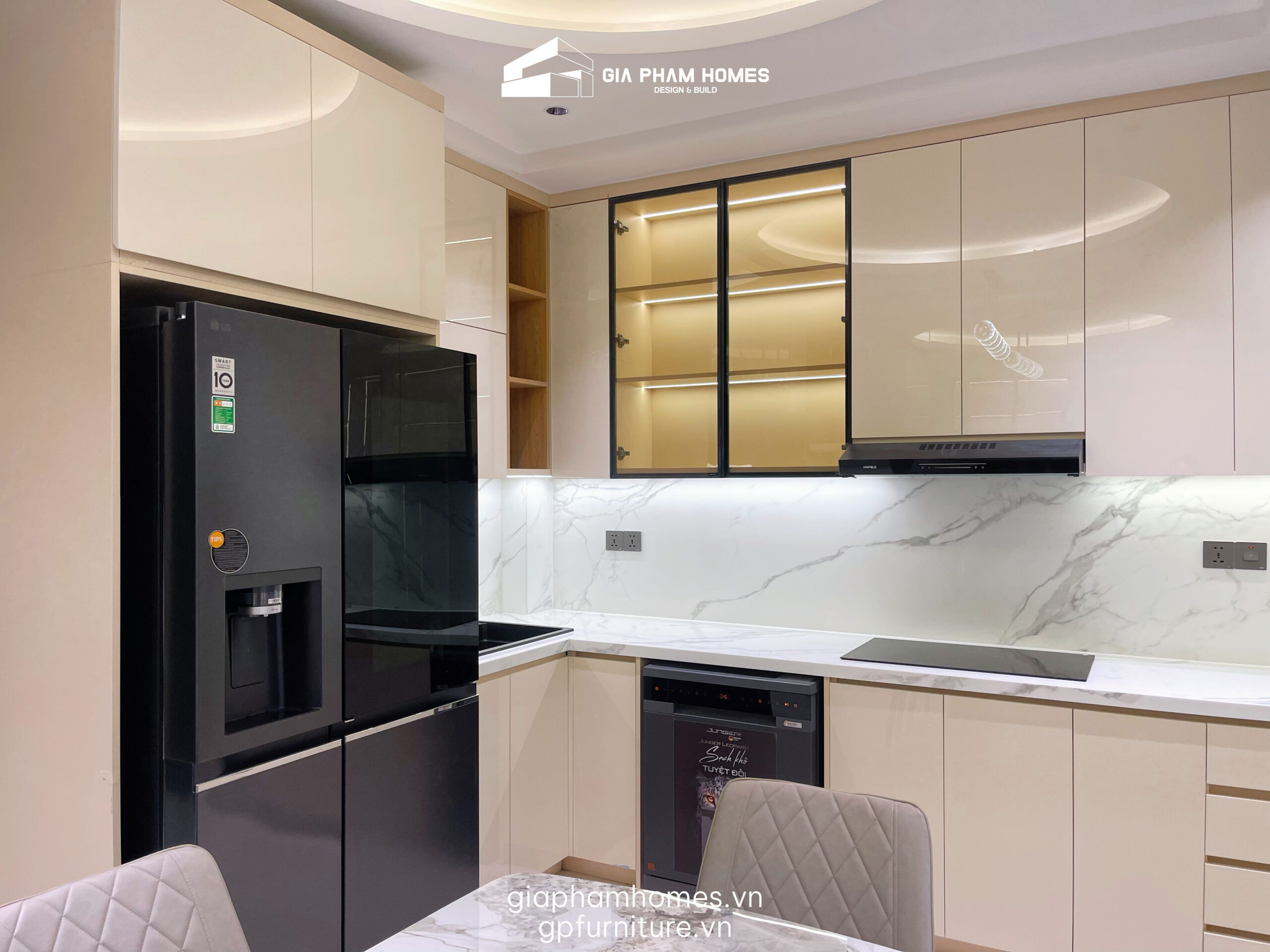 2. Phòng Bếp: Tiện Nghi Từng Centimet
Khu vực bếp nấu được thiết kế theo tiêu chí: Sạch sẽ - Gọn gàng - Sang trọng.
Tủ bếp Acrylic bóng gương: Sử dụng cốt gỗ MDF chống ẩm phủ Acrylic tông màu beige nhã nhặn. Bề mặt bóng gương không chỉ đẹp mà còn giúp gia chủ dễ dàng vệ sinh dầu mỡ.